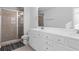 Modern bathroom with double vanity, white cabinets, shower, and tile floor at 2527 Hedgeway Cir, Kennesaw, GA 30144