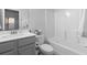 Well-lit bathroom with gray cabinets, a white countertop, toilet, and shower/tub combo at 2527 Hedgeway Cir, Kennesaw, GA 30144