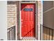 Close-up of a bright red front door with brick surround and modern black hardware at 2527 Hedgeway Cir, Kennesaw, GA 30144