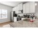 Bright kitchen featuring granite countertops, stainless steel appliances, and white cabinets at 2527 Hedgeway Cir, Kennesaw, GA 30144