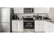 Well-equipped kitchen with stainless steel appliances, granite countertops, and stylish white cabinetry at 2527 Hedgeway Cir, Kennesaw, GA 30144