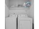 Functional laundry room features side by side washer and dryer, and overhead storage shelving at 2527 Hedgeway Cir, Kennesaw, GA 30144