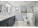 Bathroom featuring double vanity, patterned tile floor, toilet and a walk-in shower with glass enclosure at 411 Buckingham Cir, Marietta, GA 30066