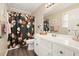Bright bathroom featuring a neutral color scheme, floral shower curtain, and large mirror at 411 Buckingham Cir, Marietta, GA 30066