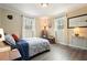 Comfortable bedroom with two windows, bedside tables, patterned bedding, and laminate floors at 411 Buckingham Cir, Marietta, GA 30066
