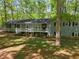 Inviting home showcasing a covered porch, complemented by mature trees and well-maintained lawn at 411 Buckingham Cir, Marietta, GA 30066