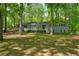 Charming single-story home with a cozy front porch, surrounded by mature trees and lush landscaping at 411 Buckingham Cir, Marietta, GA 30066