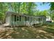 Charming one-story home featuring a covered front porch, shutters, and lush green landscaping at 411 Buckingham Cir, Marietta, GA 30066