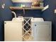Functional laundry room with washer, dryer, folding rack and upper shelf storage at 411 Buckingham Cir, Marietta, GA 30066