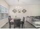 Well-lit dining area featuring modern chandelier, decor and seating for four adjacent to the living room at 7206 Begonia Way # 4, Austell, GA 30168