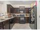 Dark kitchen with granite countertops, tile backsplash and modern appliances including black oven and fridge at 7206 Begonia Way # 4, Austell, GA 30168