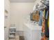 Bright laundry room with washer, dryer, shelving, and hanging rack for clothes storage at 7206 Begonia Way # 4, Austell, GA 30168