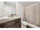 Well-lit bathroom featuring a single sink with stylish dark vanity and shower with neutral-colored curtain at 13699 Inman Rd, Hampton, GA 30228