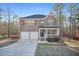Charming two-story brick home featuring a two-car garage, covered porch, and manicured lawn at 13699 Inman Rd, Hampton, GA 30228