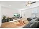 Bright living room with wood-look flooring, modern entertainment center, and natural light at 13699 Inman Rd, Hampton, GA 30228