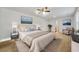 Bright primary bedroom with a large bed and artwork above it with a sitting area near the windows at 13699 Inman Rd, Hampton, GA 30228