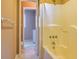 Bathroom view of a bathtub and the doorway to a separate small area containing a toilet and washing machine at 166 Muse Rd, Fayetteville, GA 30214
