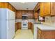 Compact kitchen with wooden cabinets, standard white appliances, and neutral countertops at 166 Muse Rd, Fayetteville, GA 30214