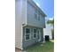 View of the home's siding, featuring symmetrically placed windows and an outdoor air conditioning unit at 2056 Belmont Cir, Conyers, GA 30012