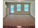 Spacious living room offering three windows and a door that leads to the outside at 2056 Belmont Cir, Conyers, GA 30012