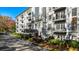 Elegant condo building exterior featuring manicured landscaping and charming black awnings over the entryway at 3201 Lenox Ne Rd # 23, Atlanta, GA 30324