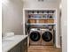 Functional laundry room boasts a side-by-side washer and dryer with ample storage on built-in shelving at 3201 Lenox Ne Rd # 23, Atlanta, GA 30324
