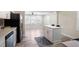 Modern kitchen with stainless steel appliances, white cabinetry, and a central island, connected to the living room at 1256 Elizabeth Sw Ave, Atlanta, GA 30310
