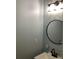 Clean bathroom with a round mirror, modern lighting fixture, and white sink at 2546 Tullamore Cir, Snellville, GA 30039