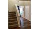 Open entryway with hardwood floors, neutral paint, staircase, and view into the next room at 2546 Tullamore Cir, Snellville, GA 30039