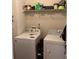 Functional laundry room with washer, dryer, and storage shelves at 2546 Tullamore Cir, Snellville, GA 30039