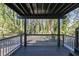 Back porch with a railing featuring a wooded view, offering a serene and private outdoor space at 353 Colchester Dr, Stone Mountain, GA 30088