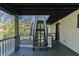 Back porch showcasing wooden stairs, white railing, and a wooded view of the outdoors at 353 Colchester Dr, Stone Mountain, GA 30088