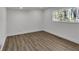 This bedroom features wood floors, a window view of the greenery, and a crisp white interior at 353 Colchester Dr, Stone Mountain, GA 30088