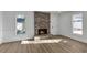 Inviting living room features a brick fireplace, wood-look flooring, and natural light from the surrounding windows at 353 Colchester Dr, Stone Mountain, GA 30088