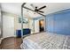 Bedroom featuring a gray canopy bed, blue walls, wood floors, and a glimpse of the en suite bathroom at 122 Belmonte Sw Dr, Atlanta, GA 30311