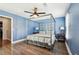 Stylish bedroom featuring a gray canopy bed, blue walls, wood floors, and ample natural light at 122 Belmonte Sw Dr, Atlanta, GA 30311