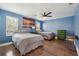 Cozy bedroom featuring hardwood floors, ceiling fan, and an ocean-themed painting at 122 Belmonte Sw Dr, Atlanta, GA 30311