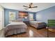 Cozy bedroom featuring hardwood floors, ceiling fan, and an ocean-themed painting at 122 Belmonte Sw Dr, Atlanta, GA 30311