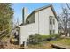 View of a two-story home with light siding, a chimney, manicured hedges and mature trees at 122 Belmonte Sw Dr, Atlanta, GA 30311