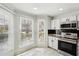 Bright kitchen eating area with large windows offering natural light and black subway backsplash at 122 Belmonte Sw Dr, Atlanta, GA 30311