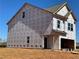 New construction home showing exterior framing details and wrapped for weather protection on a sunny day at 1227 Riverstone Rd, Jonesboro, GA 30238