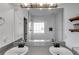 Bright bathroom with double sinks, large mirror, subway tile shower, and floating shelves at 121 Fox Wood Ct, Villa Rica, GA 30180