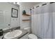 Compact bathroom with a single vanity, white shower curtain, and floating wooden shelves at 121 Fox Wood Ct, Villa Rica, GA 30180