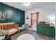 Charming Bedroom with green accent wall, wooden crib, and matching green dresser at 121 Fox Wood Ct, Villa Rica, GA 30180