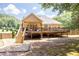Exterior view of an elevated back porch and deck with stairs leading to a spacious backyard with wood privacy fence at 2515 Little John Ct, Cumming, GA 30040