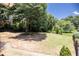 Large backyard with grassy area and ample space, shaded by mature trees on a sunny day at 2515 Little John Ct, Cumming, GA 30040