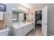 Bathroom with double sinks, large mirror and doorway to Primary bedroom at 2515 Little John Ct, Cumming, GA 30040