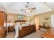 Large bedroom has a tray ceiling and is furnished with wooden furniture and lamps at 2515 Little John Ct, Cumming, GA 30040