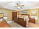 Spacious bedroom featuring a tray ceiling, ceiling fan, and coordinating wooden furniture at 2515 Little John Ct, Cumming, GA 30040