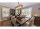Elegant dining room with a wooden table, stylish chandelier, and sun-filled windows at 2515 Little John Ct, Cumming, GA 30040